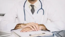 close-up-male-doctor-s-hand-with-clipboard-desk