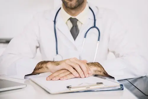 close-up-male-doctor-s-hand-with-clipboard-desk