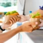 man-buying-two-hot-dog-kiosk-outdoors-street-food-close-up-view-scaled-1